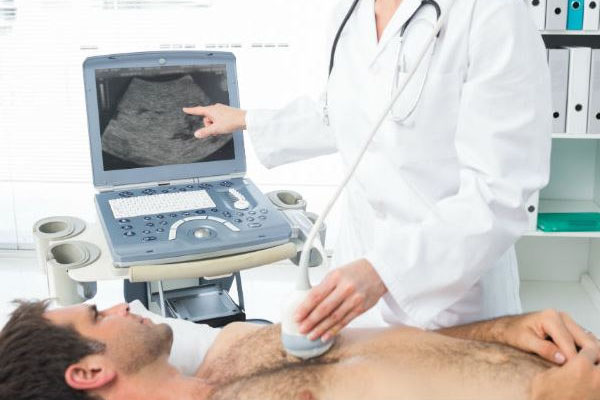 Hombre recostado mientras le hacen un ecocardiograma de estrés mediante un ultrasonido
